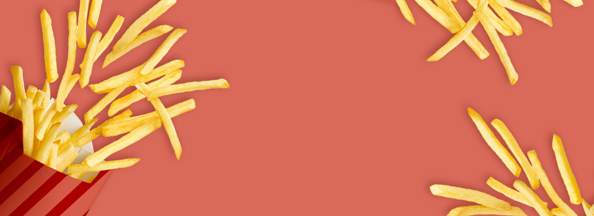 A container of fries spilled across a light red background.