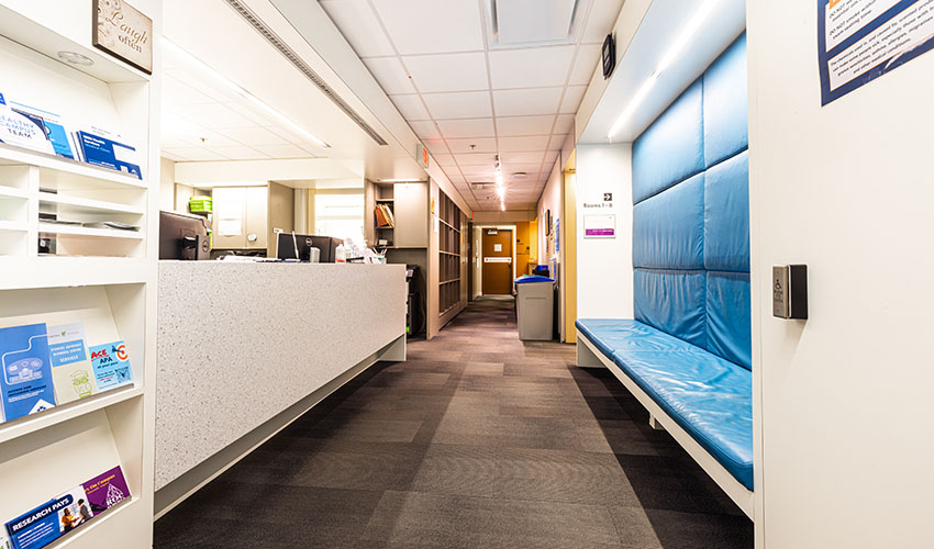 Looking into the Access and Inclusion Centre from the entrance. There is a padded booth seat to the right and a welcome desk to the left.