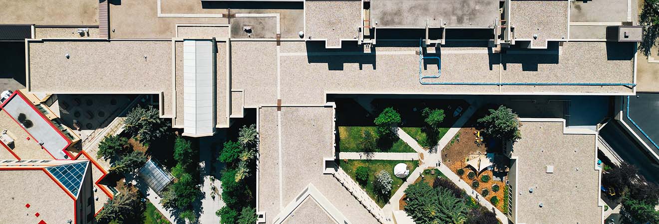 Aerial view of the main body of campus featuring courtyards, greenspaces and brutalist architecture.