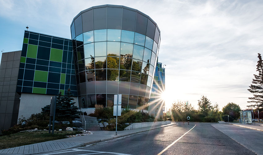 Photo of the new extension of the Wyckham House Student Centre - there is a curved glass and metal section and a flat section with blue and green squares.