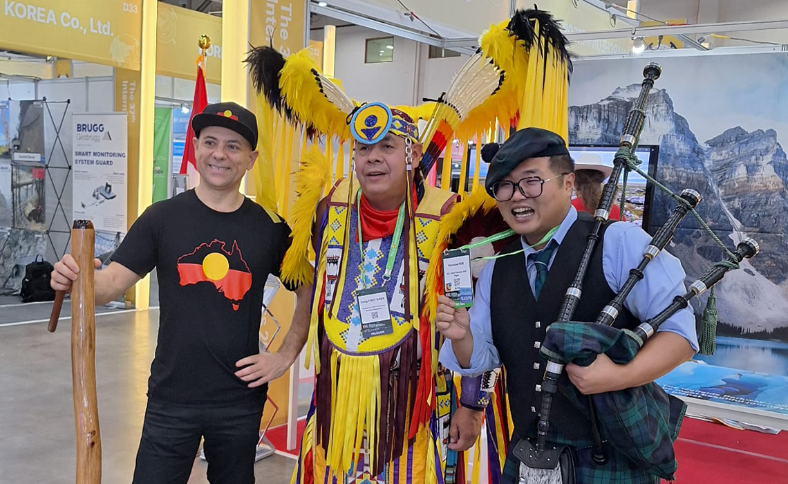 A powerful moment captured featuring a Blackfoot dancer supporting Calgary, a South Korean bagpiper for Glasgow and an Australian didgeridoo player — showcasing global unity through diverse cultural support at the bid presentation.