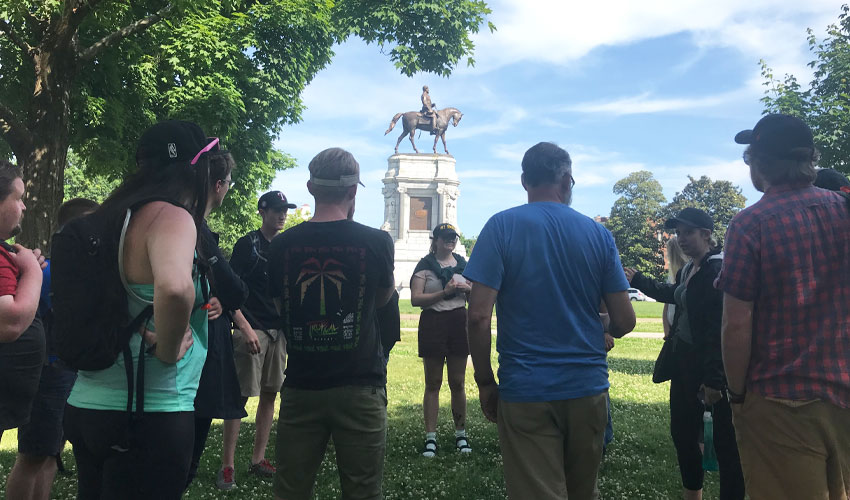 Students gather near a statue of Robert E. Lee, commander of the Confederate Army of Northern Virginia and a controversial figure in American lore. Student Sarah Pointer, second from right, speaks to the group.