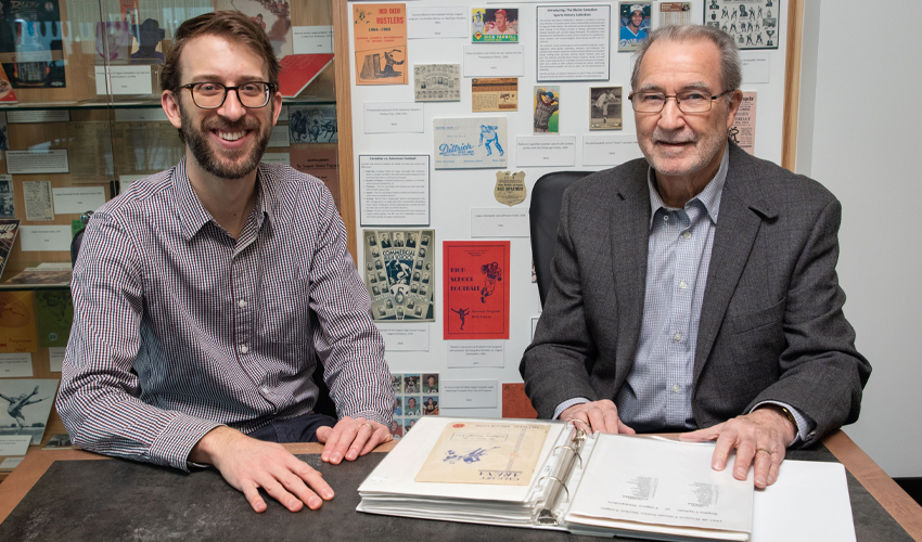 Mount Royal University Archivist and Special Collections Librarian Peter Houston, left, and Robert Blaine who donated the sports memorabilia history collection.