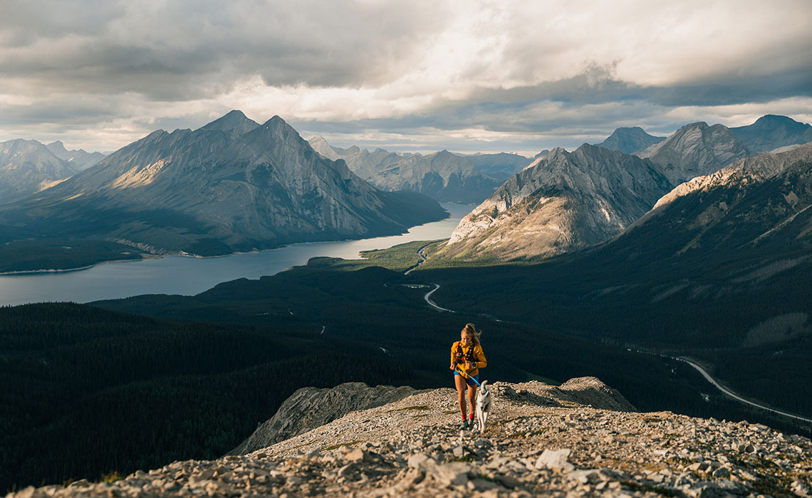 Woman trail running with her dog in Kananaskis Country, Alberta.