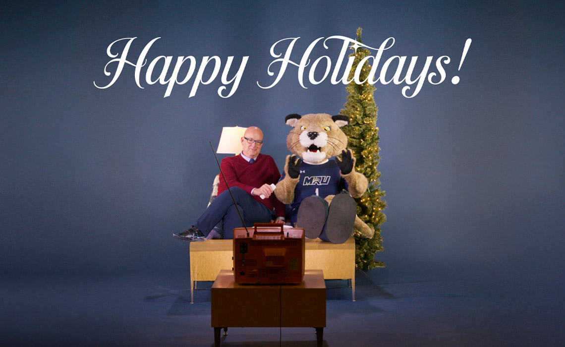 Tim Rahilly, PhD and Calvin watch a holiday video together. 