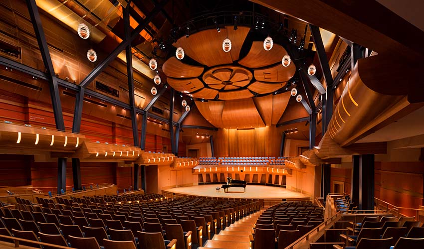 A concert hall made out of many panels of warm coloured wood.