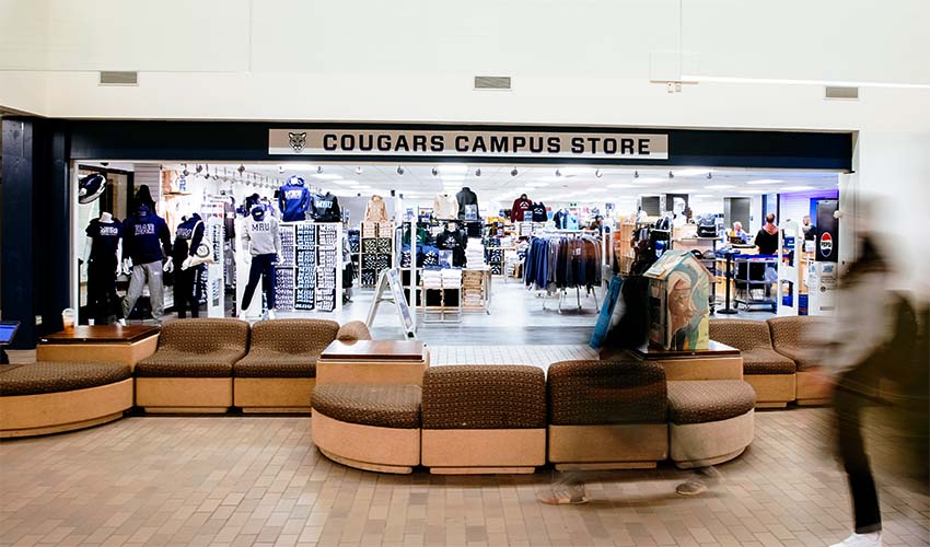 A photo looking into a store with many shirts, hoodies, crewnecks and other items from a hallway.