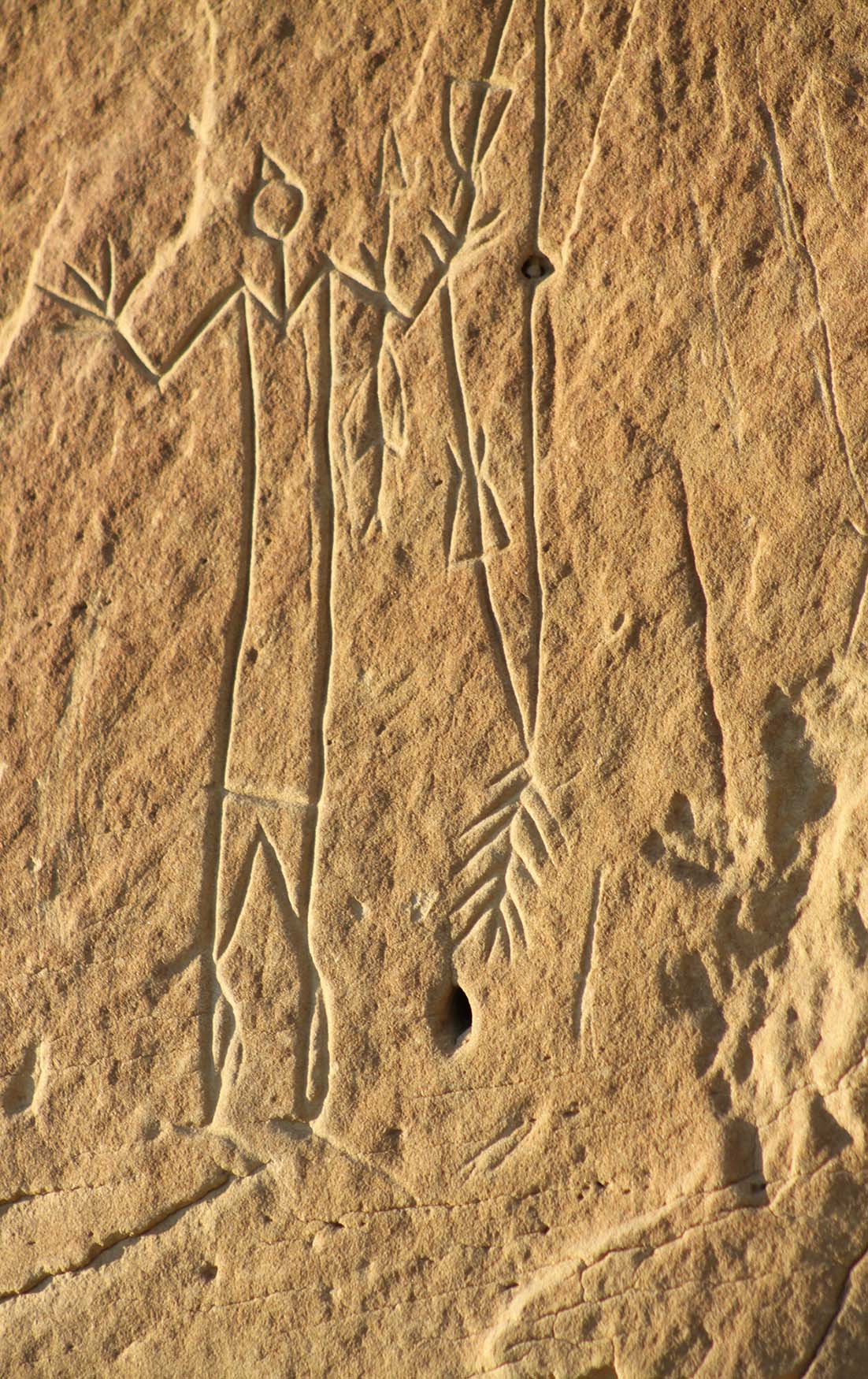 Rock carving of a person holding a bow.