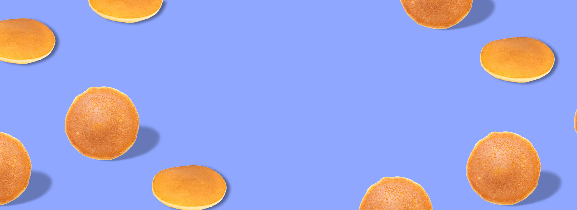 A pattern of pancakes on a dark periwinkle blue background.