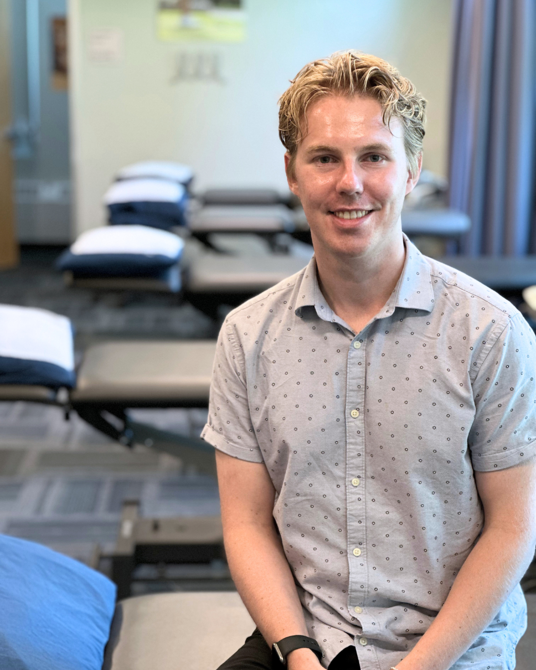 Greg Douglas sitting in the Injury and Prevention Clinic rehab spaceglas-IPC-Practitioner.png