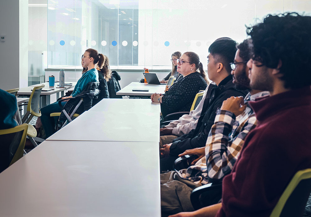 A group of Tech Liftoff participants listening to a presentation in the Riddell Library and Learning Centre.