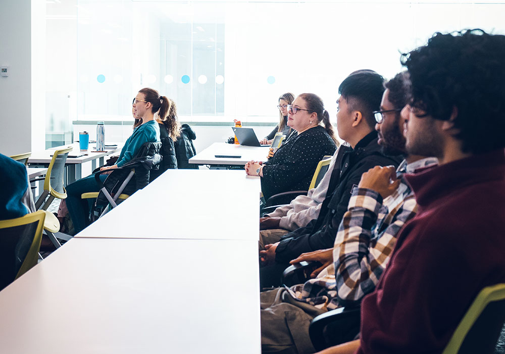 A group of people in a classroom in the Riddell Library and Learning Centre listening to someone speak