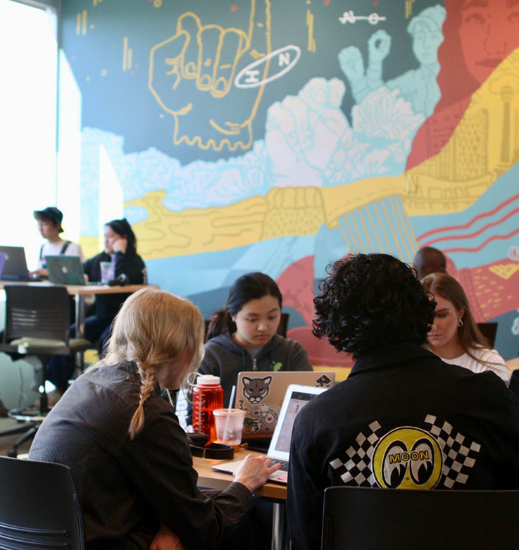 People collaborating at several tables in the Slate Innovation Lab.