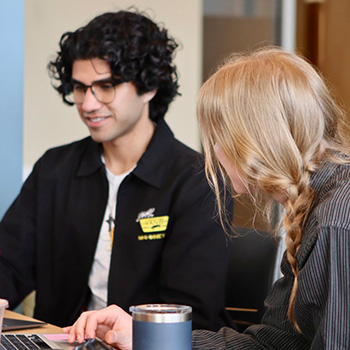 Sunny Parmar at a desk with another participant.