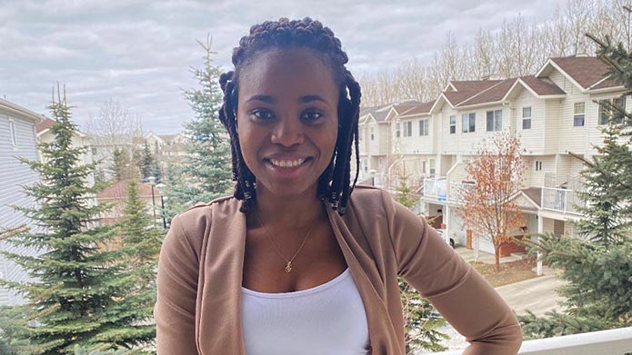 Maryjane Kanikwu smiling with a Calgary neighborhood in the background.