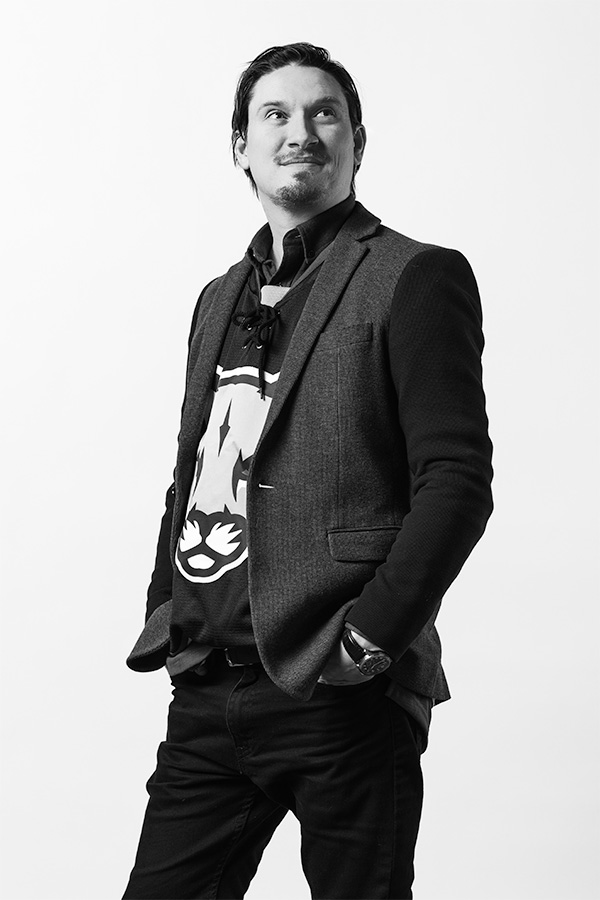 Black and white photo of Ryan Kazmerik in a blazer and MRU Cougars t-shirt.