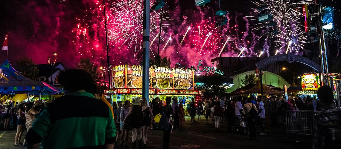 Fireworks illuminate the night sky above the Calgary Stampede midway