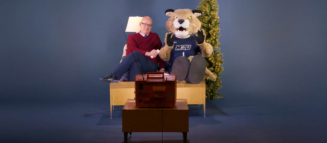 Tim Rahilly seated next to Calvin the Cougar