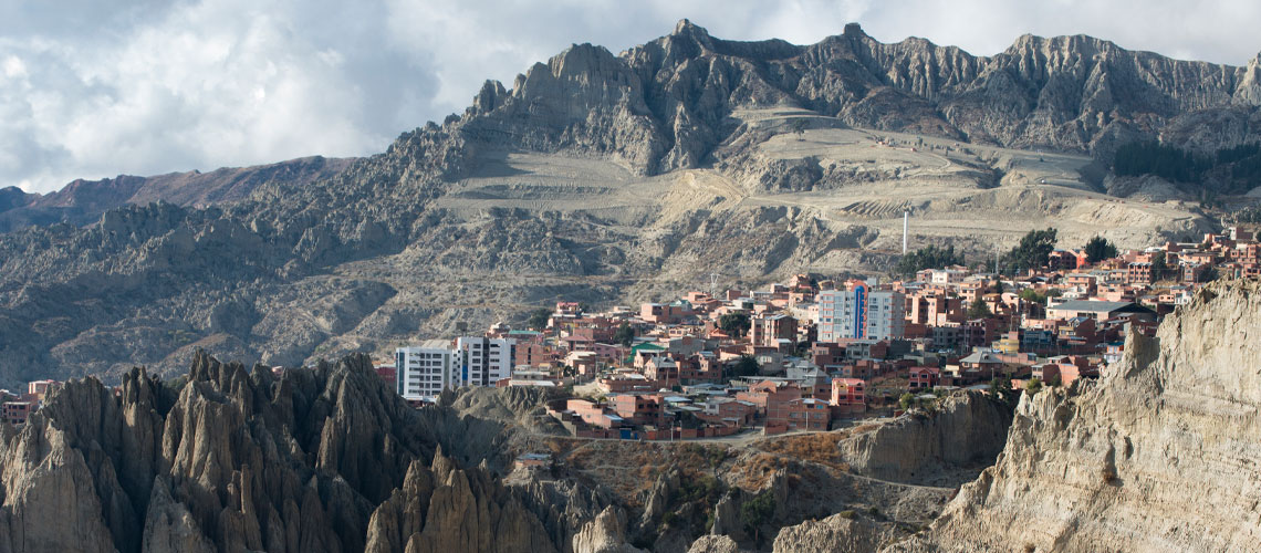 A panoramic view of a city perched on a mountain's edge, showcasing numerous buildings against a stunning landscape.