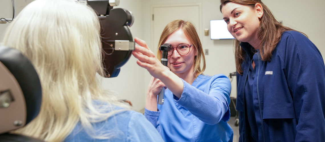 A woman undergoing an eye examination with a student optometrist